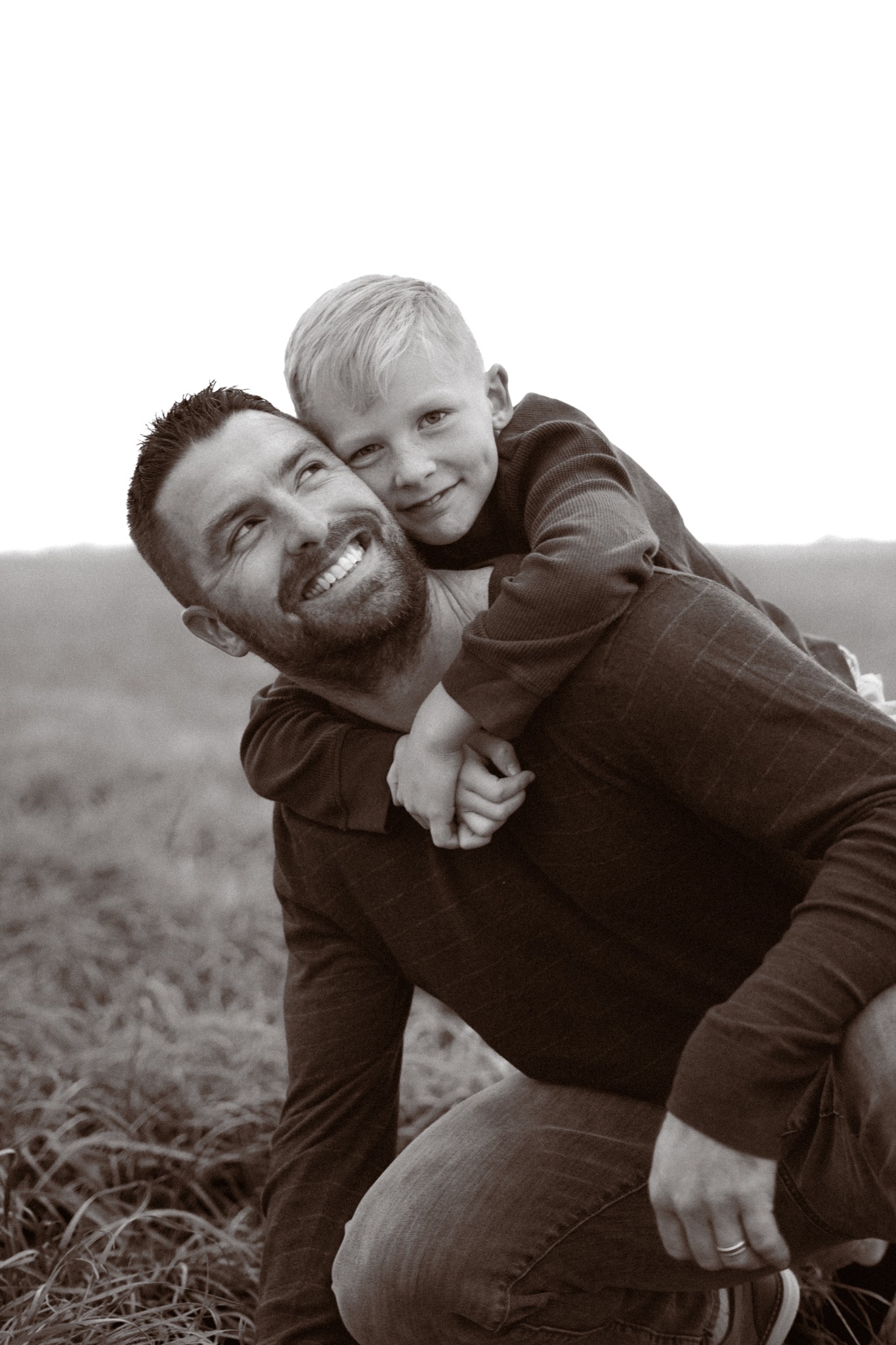A father carrying his son while they laugh together