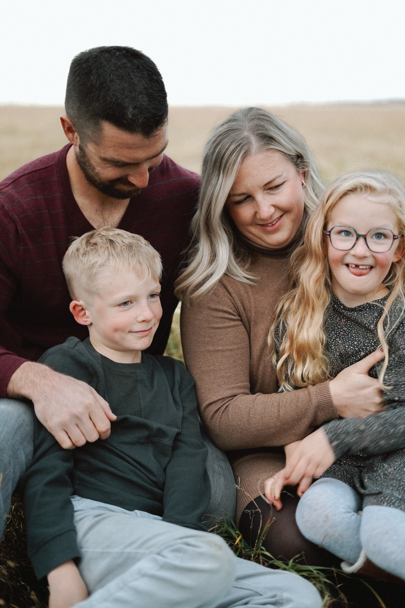 A family sitting closely together in a field