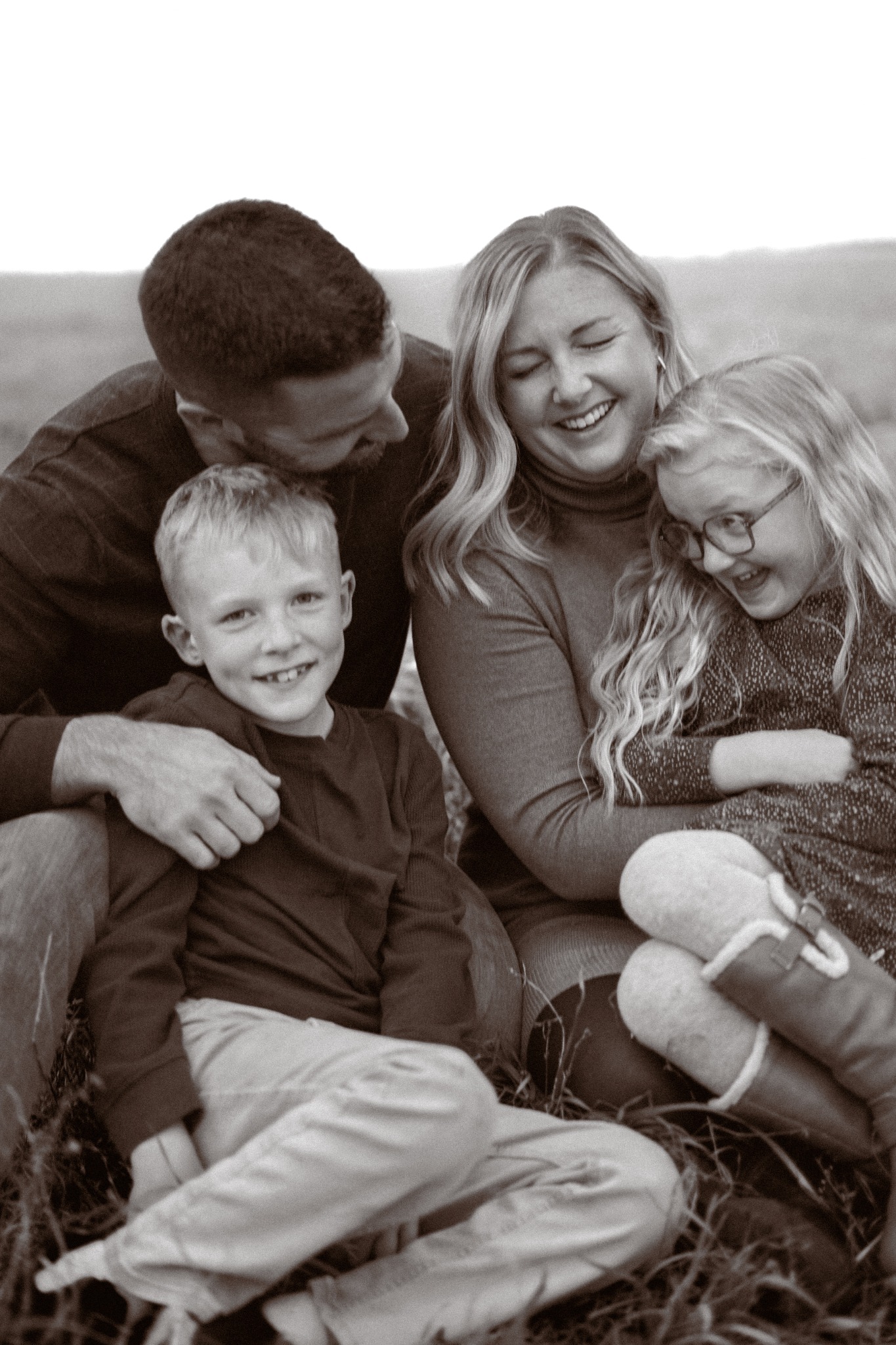 A family laughing together in a prairie field
