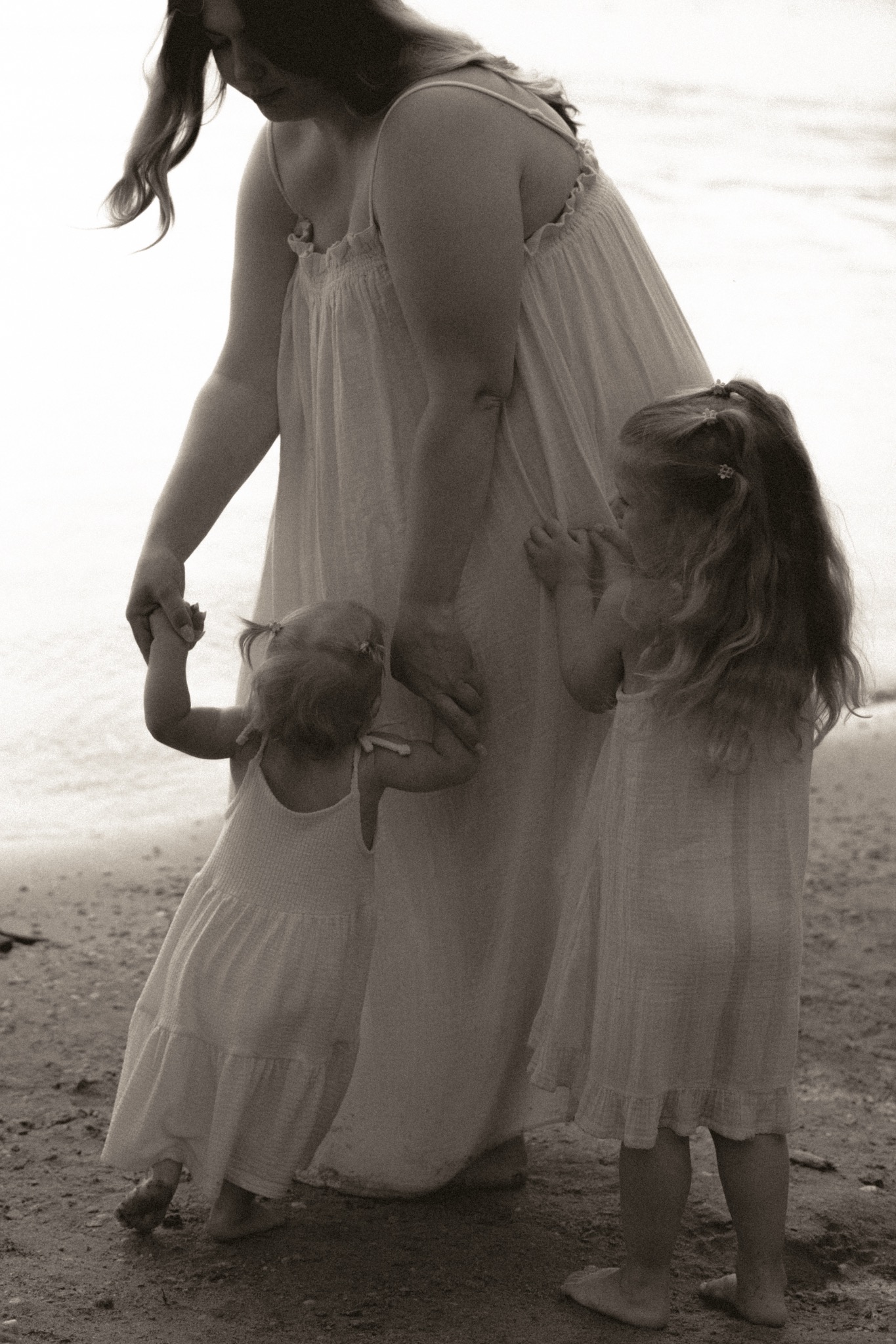 A mother standing at the lake with her daughters